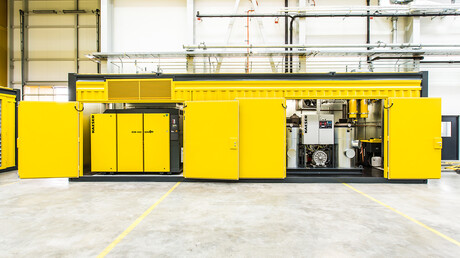 Otvorený kontajner na stlačený vzduch s viditeľnými skrutkovými kompresormi od spoločnosti Kaeser Kompressoren.